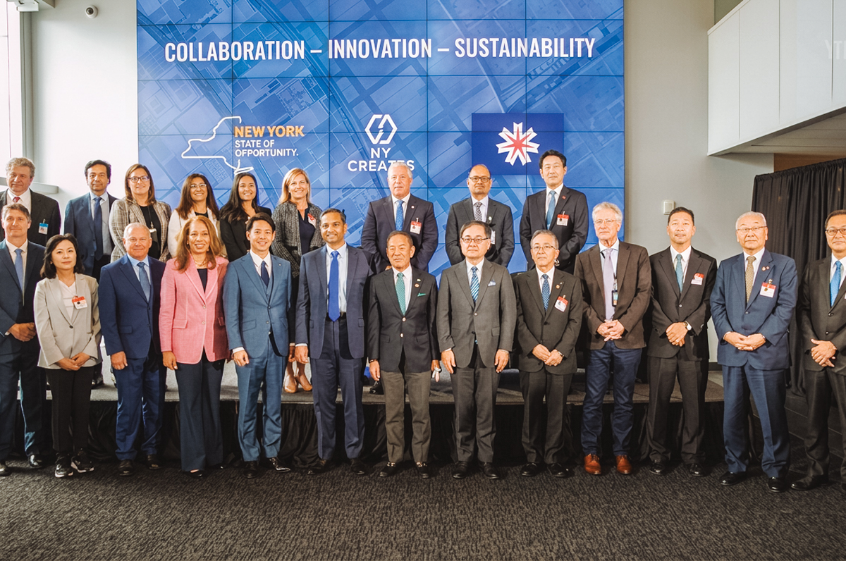 Large group posing in front of a backdrop reading 